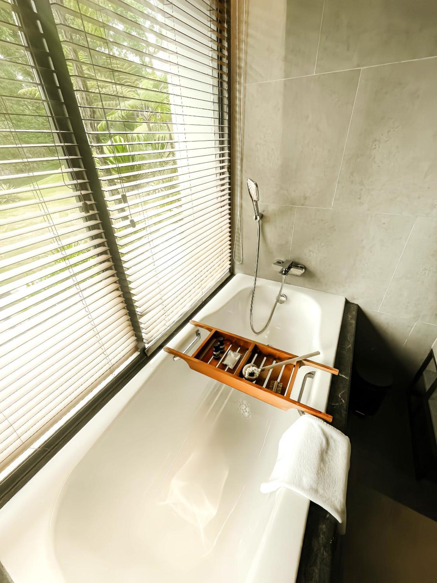 The Botanica Sanctuary Puncak Quarto foto A bathtub with a shower